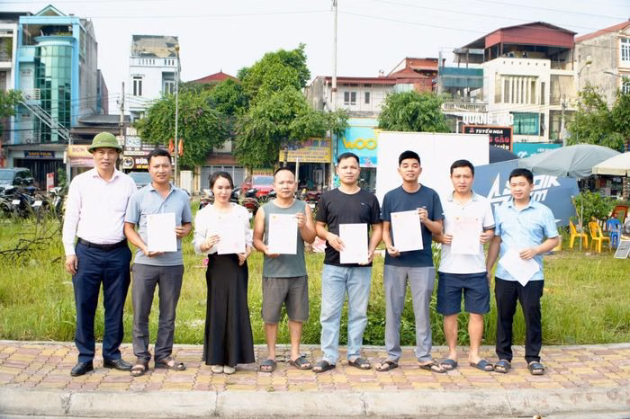 Ông Trần Văn Hòa trao giấy chứng nhận quyền sử dụng đất cho các khách hàng hoàn thành nghĩa vụ tài chính. Ảnh: Hữu Dũng